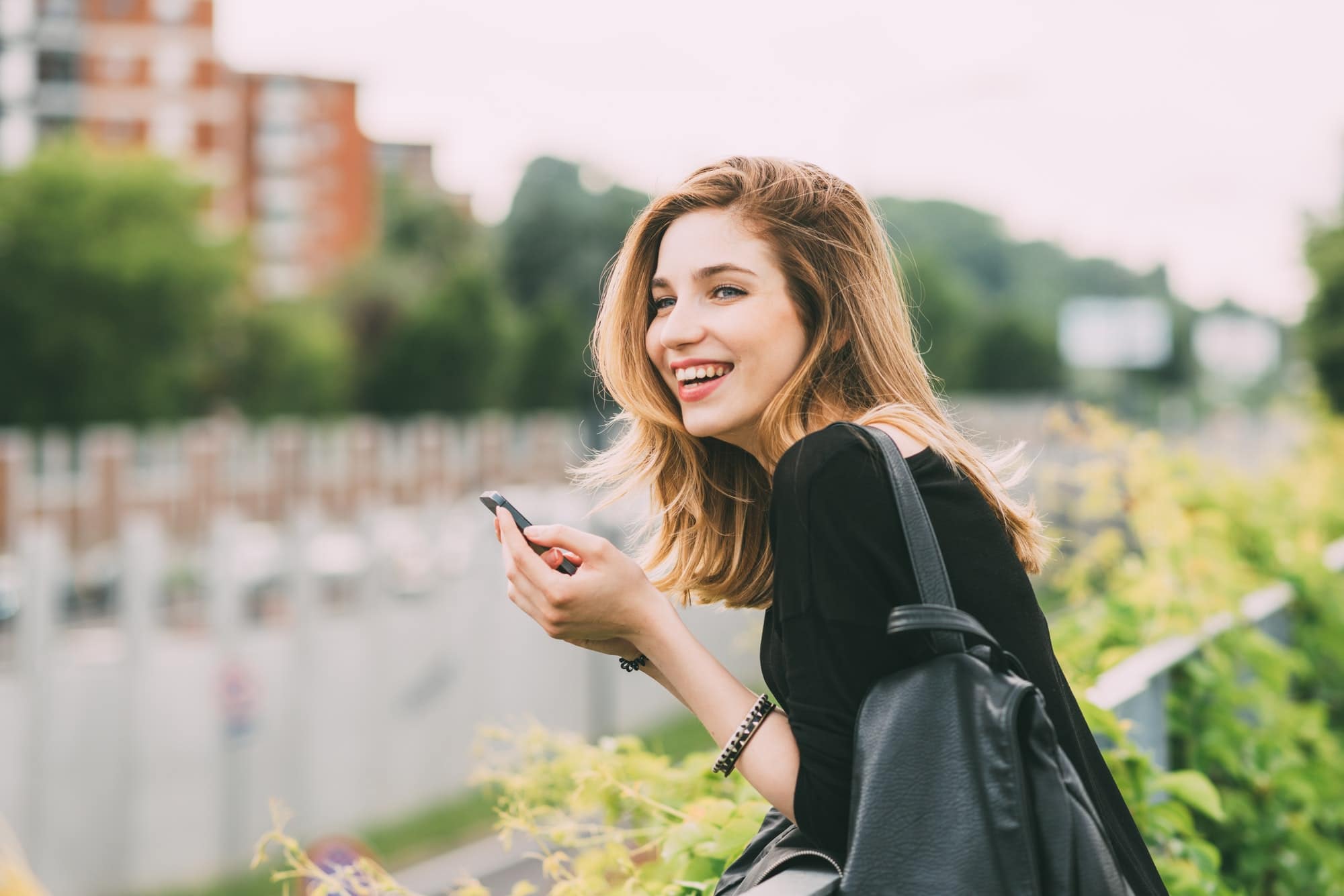 Young woman using smartphone laughing